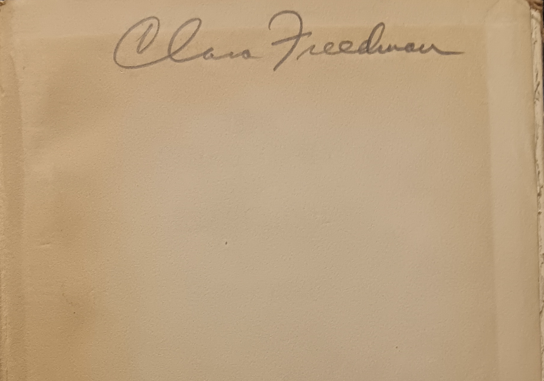 A close-up photo of a yellowed page with a handwritten signature at the top reading “Clara Freedman.”.