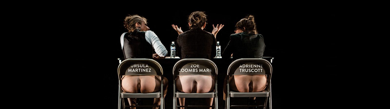 Three people sit on chairs with their backs to the camera; their bare buttocks are visible through cutouts in the chairs, which each display a name: Ursula Martinez, Zoe Coombs Marr, and Adrienne Truscott.
