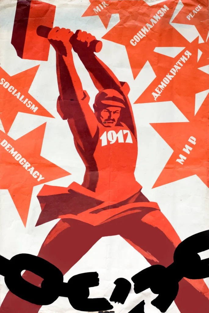 A stylized figure in red swings a hammer marked “1917,” breaking black chains, with red starbursts containing words like “SOCIALISM,” “DEMOCRACY,” “МИР,” and “DEMOCRACY” on a white and red background.