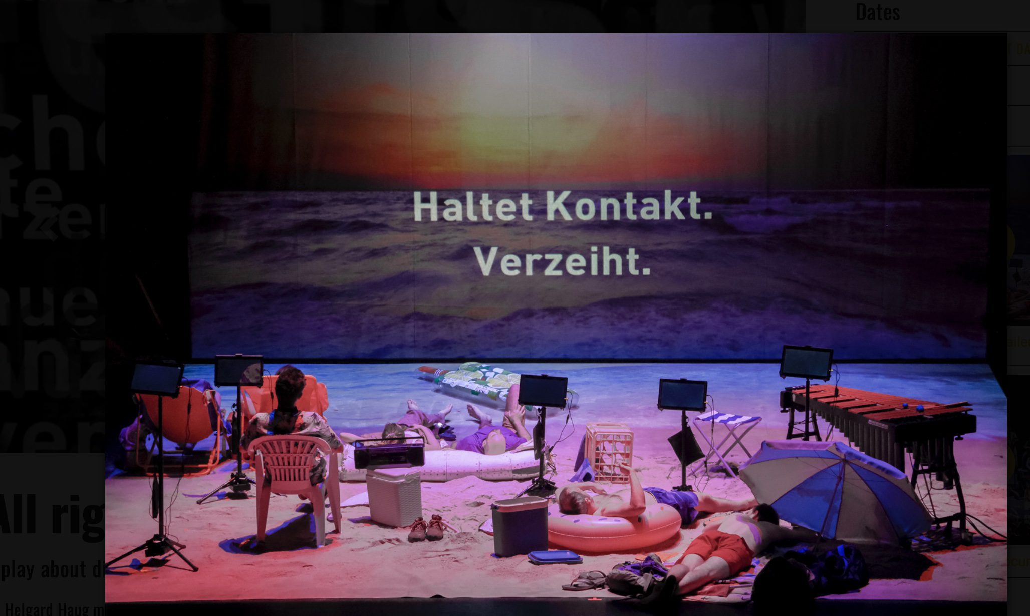 A stage set like a beach with scattered chairs, umbrellas, and beach toys. Several people lounge or sit. The backdrop shows a sunset over the sea with German text: “Haltet Kontakt. Verzeiht.”.
