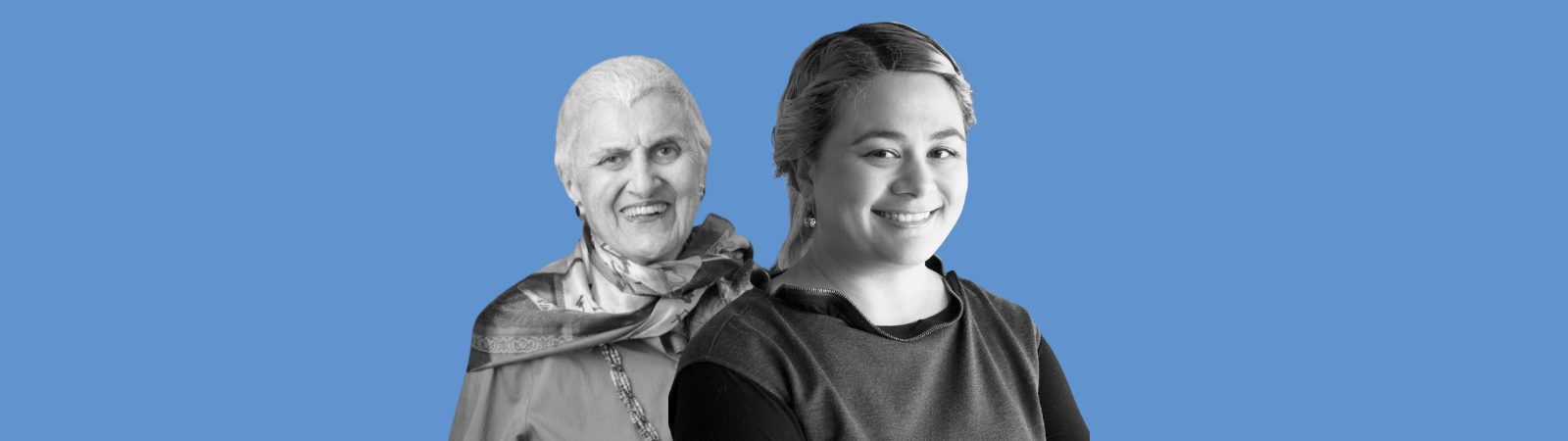 An older woman with short white hair and a scarf stands beside a younger woman with pulled-back hair, both smiling, on a blue background.