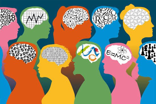 Colorful silhouettes of heads in profile, each with a brain area filled with different symbols such as numbers, letters, puzzles, graphs, formulas, and chess pieces, representing diverse ways of thinking and learning.